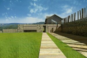 Podjazd do budynku domu jednorodzinnego ze strefą wejściową i murem oporowym.