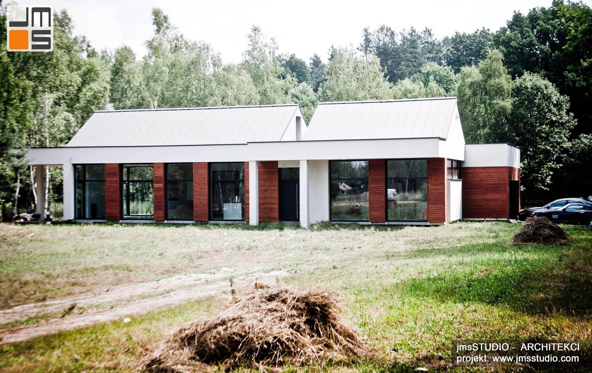 nowoczesny projekt prostego domu z dużymi przeszkleniami drewnem na elewacji i blachą na rąbek na dachu pod Brzeskiem