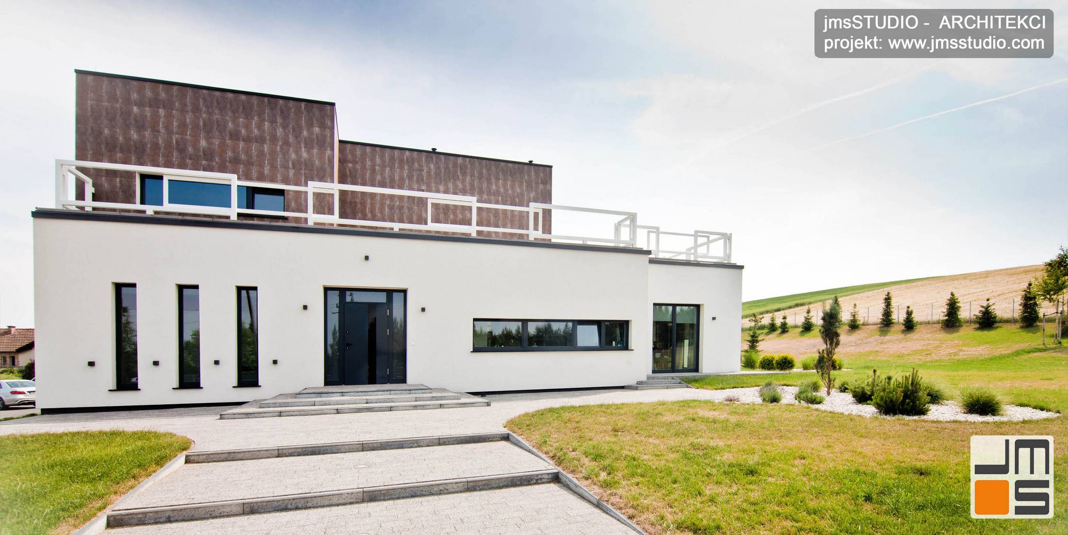 Architekt Kraków projekt dużego ekskluzywnego domu z ciekawym detalem elewacją w kolorze białym z pionowymi oknami w stolarce aluminiowej pod Poznaniem