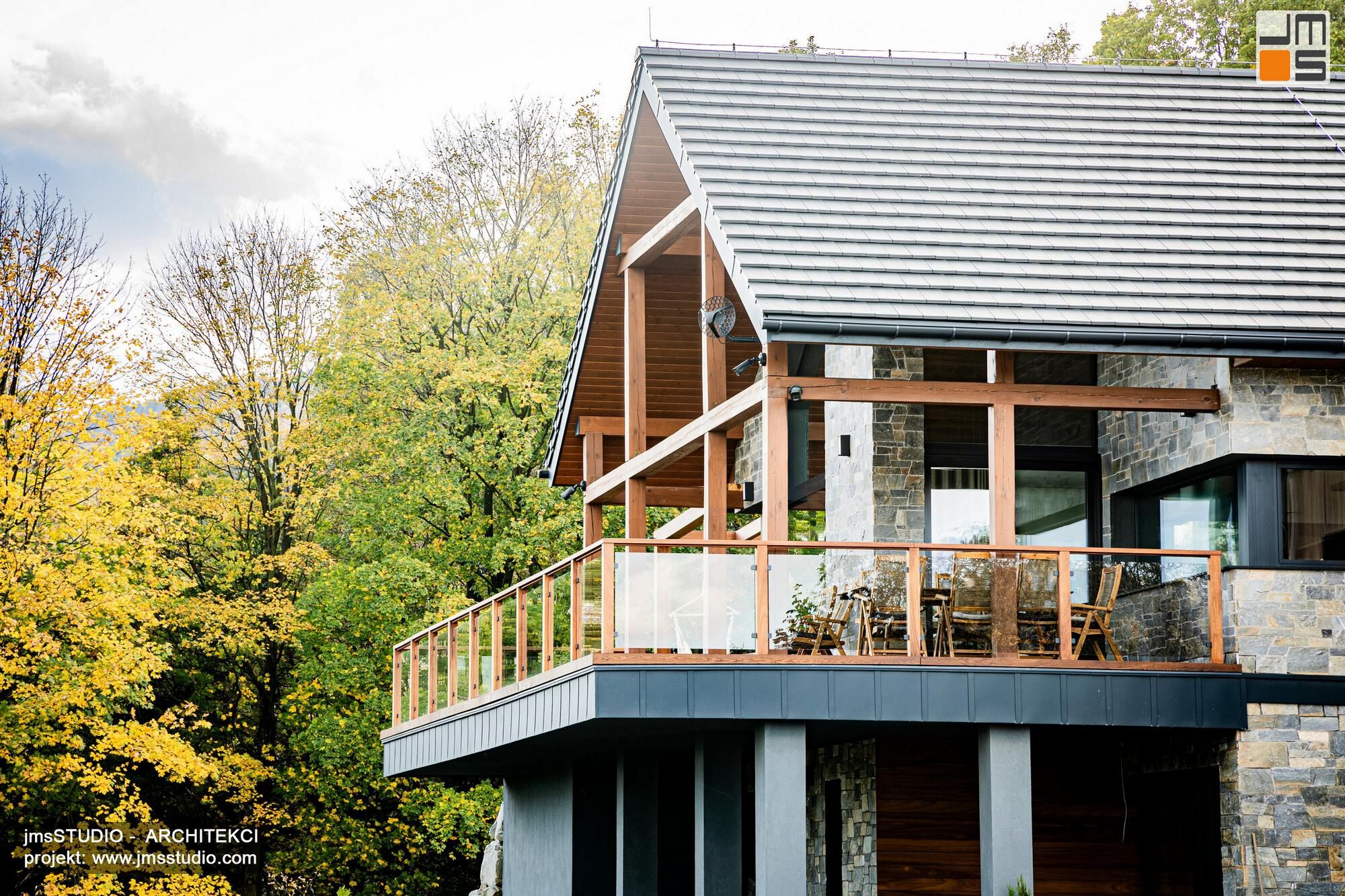 bardzo duży taras z częściowym zadaszeniem i widoczną konstrukcją drewnianą z widokiem na góry to oryginalny pomysł w nowoczesnym projekcie rezydencji w górach