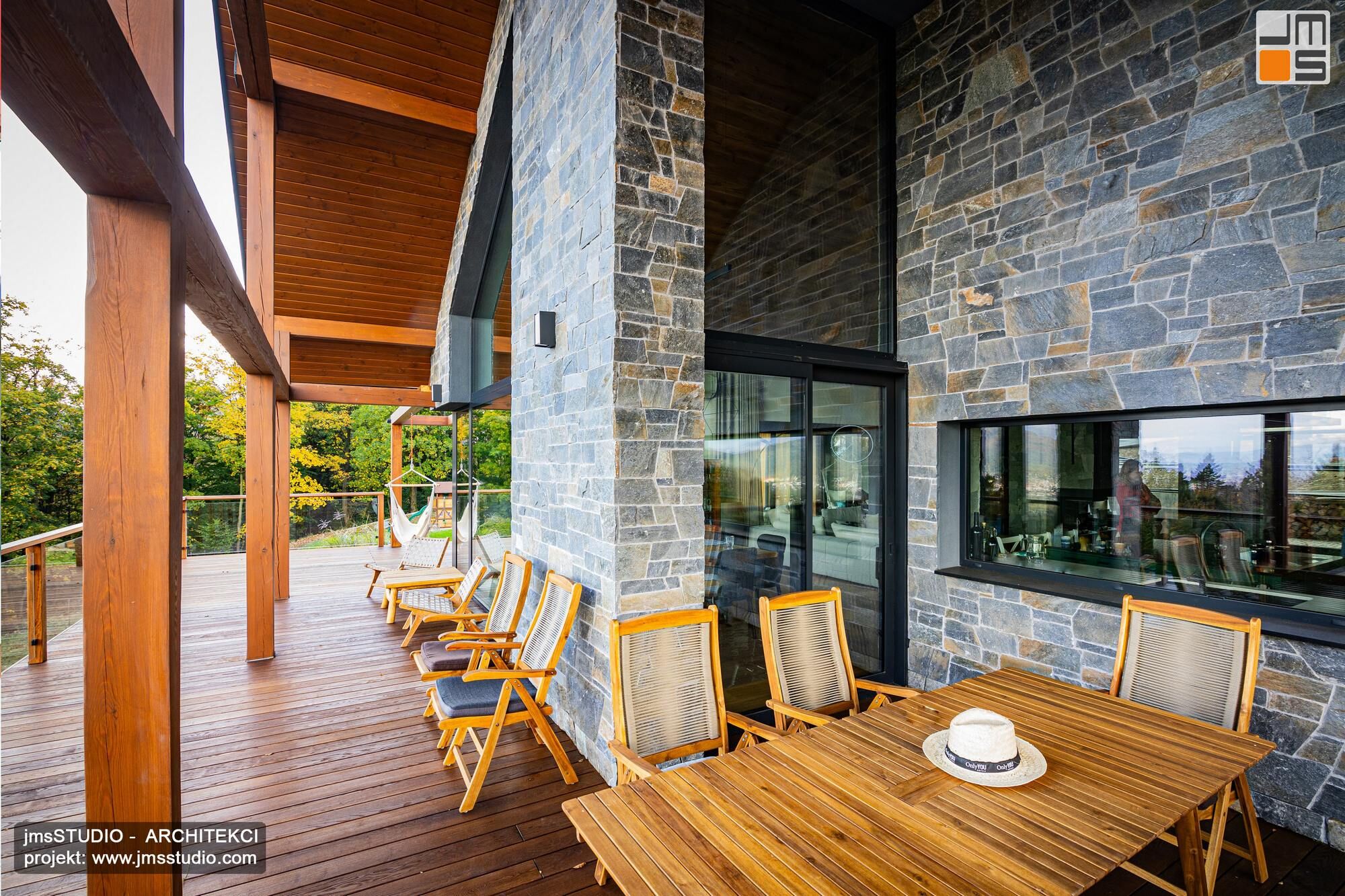 otwarta drewniana konstrukcja dachu świetnie współgra z tarasem wykonanym z którego roztacza się widok na góry - to projekt  nowoczesnej rezydencji na spadku w górach