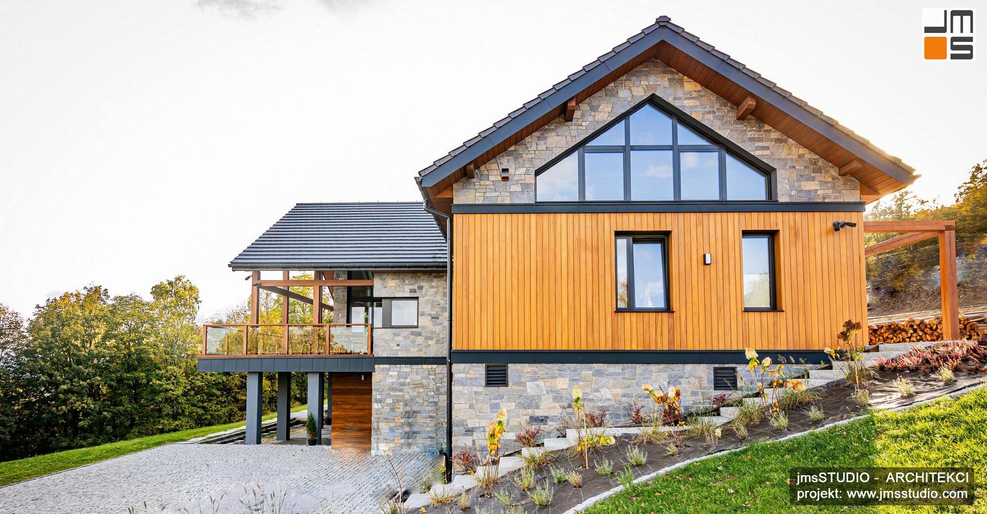 piękna kamienne  elewacja z dekoracyjnym drewnem i antracytową stolarką aluminiową to eleganckie rozwiązanie dla nowoczesnego projektu budynku w górach