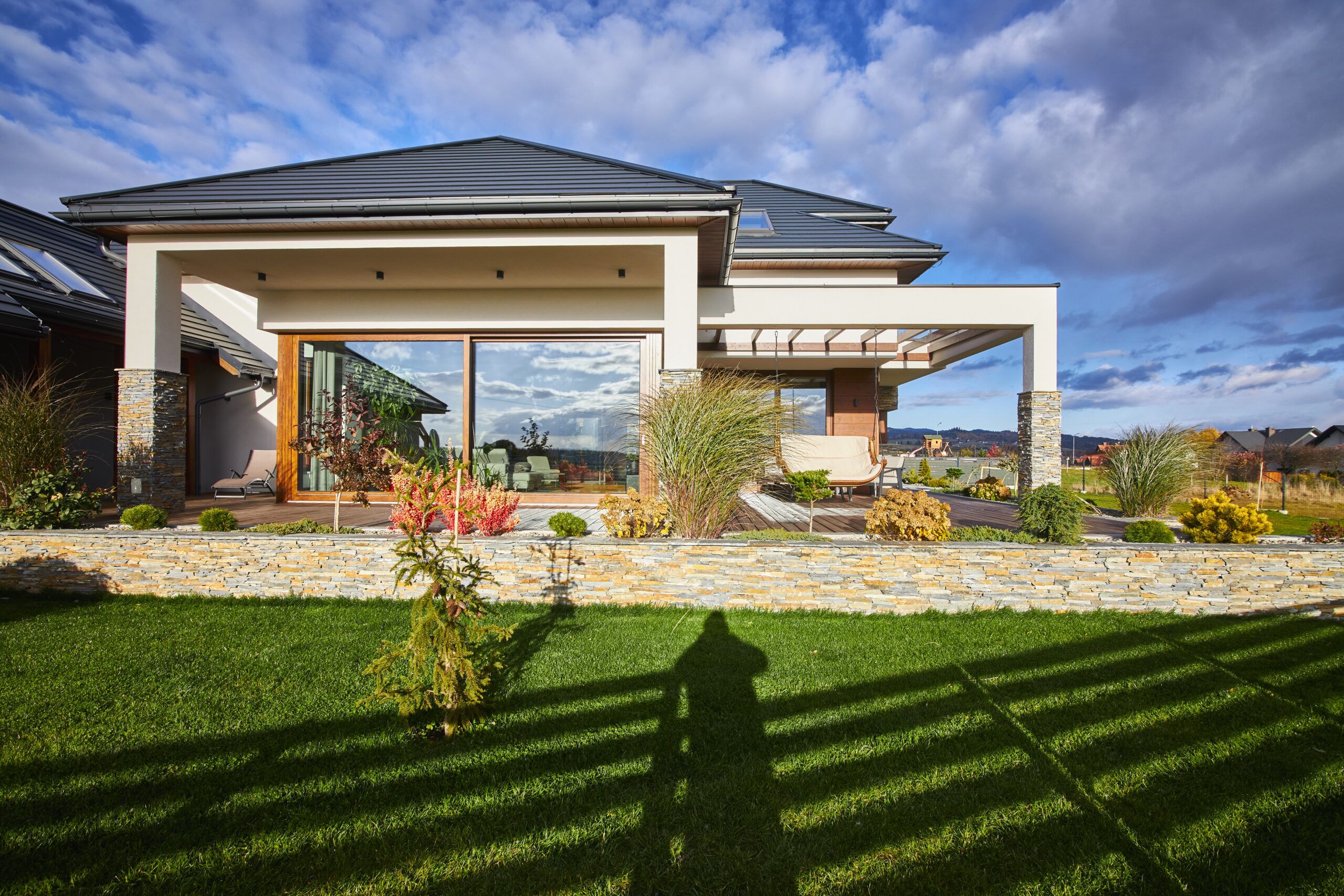 Piękne duże przeszklenie to wielkie okno przesuwne na taras w nowoczesnym dużym domu z dekoracyjną ramą w Nowym Sączu