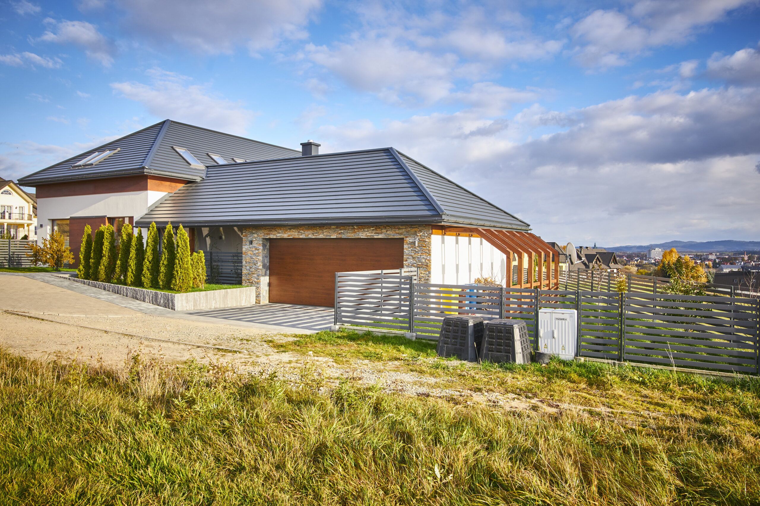 wielospadowy dach przechodzący w pergolę to pomysł na wpisanie dużego domu w działkę ze spadkiem terenu w Nowym Sączu