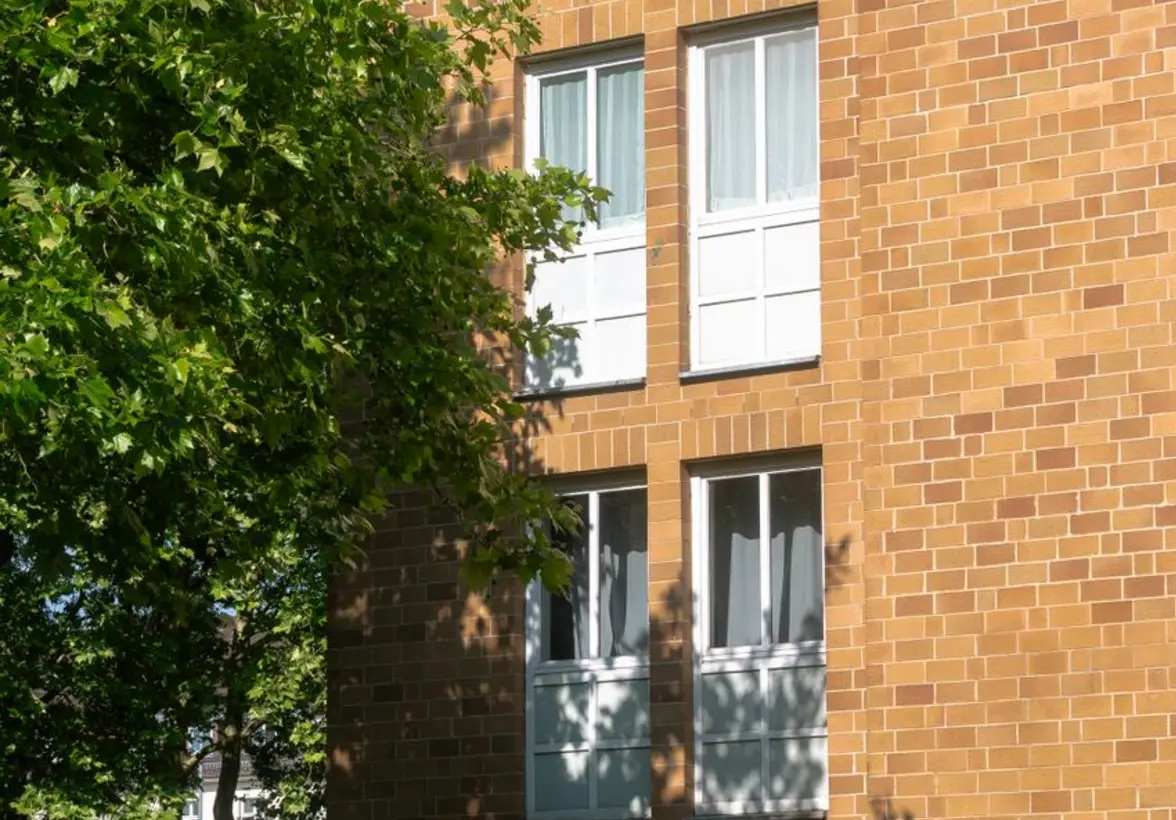 MOKOPOLIS na Służewcu – widok budynku mieszkalnego z zielonym dziedzińcem i charakterystyczną fasadą z prefabrykatów